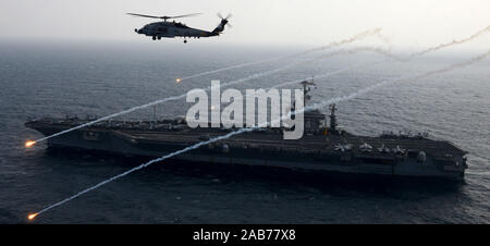 (Feb. 15, 2013) An MH-60R Sea Hawk from the Raptors of Helicopter Maritime Strike Squadron (HSM) 71 launches flares alongside the aircraft carrier USS John C. Stennis (CVN 74). Stock Photo
