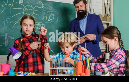 Science and education. chemistry lab. back to school. happy children teacher. children making science experiments. Education. doing experiments with liquids in chemistry lab. Doing research. Stock Photo