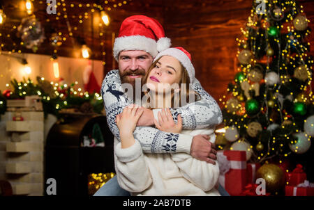 Cheerful mood. Couple in love enjoy christmas holiday celebration. Christmas time. Happy new year. Lovely married couple cuddle christmas tree background. Happiness concept. Bearded man and woman. Stock Photo