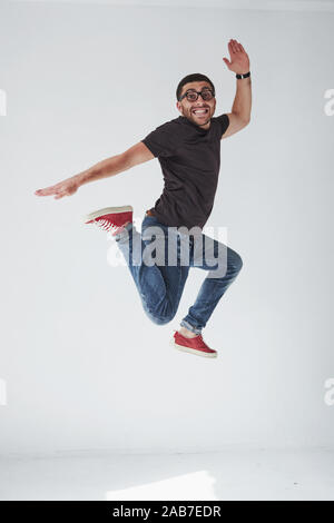 Image of cheerful young man casual dressed jumping over white background make different gesture Stock Photo