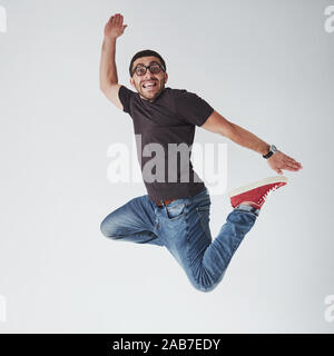 Image of cheerful young man casual dressed jumping over white background make different gesture Stock Photo