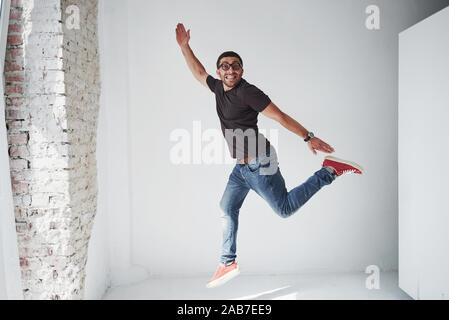 Image of cheerful young man casual dressed jumping over white background make different gesture Stock Photo