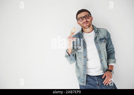 Young handsome male business executive in casual attire holding a credit card in the pockets on a white background. The concept of trading on the Stock Photo