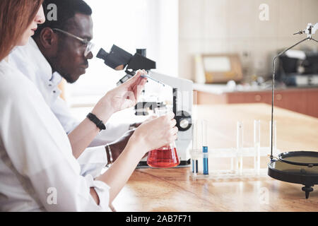 Scientists work closely with the microscope in the laboratory by conducting experiments and analyzes. Stock Photo