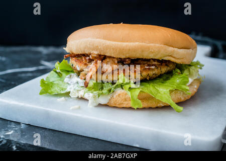 Homemade Salmon Burger with Tartar Sauce, Onion and Lettuce on Marble Board. Ready to Eat. Stock Photo