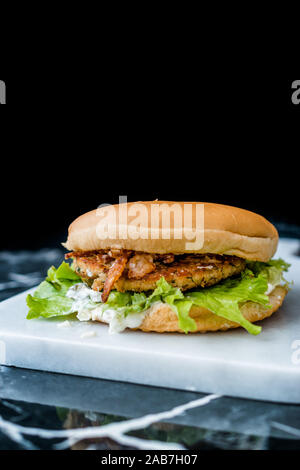 Homemade Salmon Burger with Tartar Sauce, Onion and Lettuce on Marble Board. Ready to Eat. Stock Photo