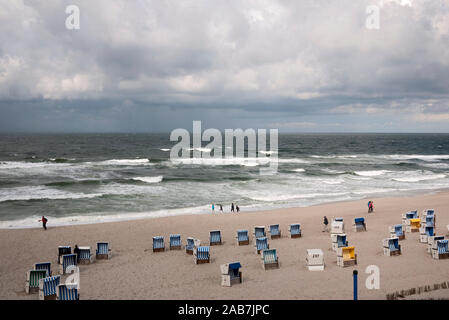 Strand mit Strandkoerben unter Regenwolken Stock Photo