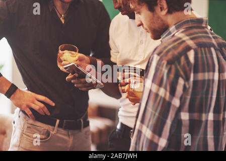 Group of friends guys with glasses of whiskey. Concept party, bachelor party barbershop. Stock Photo
