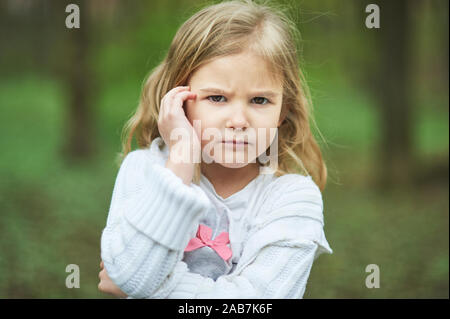 Portrait of sad unhappy little girl. Little sad child is lonesome. upset and distraught angry facial expression Stock Photo