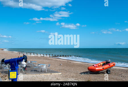 Littlehampton, West Sussex, UK, September 04, 2019. Beach view with a telescope in foreground and with RNLI boat and a cafe. Stock Photo