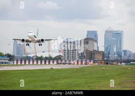 CITY AIRPORT, LONDON, ENGLAND, MAY 2 2014 Alitalia jet airplane landing, May 2 2014 at City Airport, London, England by the O2 Arena and Canary Wharf Stock Photo
