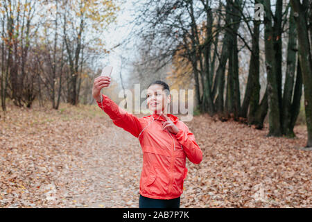 fitness woman training outside and taking selfie in the park. Stock Photo