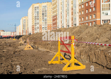 Wood protective barrier fences with protective white-red tape during repair work. Signal fences along the street. Construction work on the street, roa Stock Photo