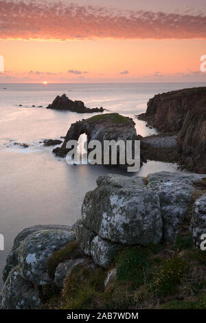 A colourful sunset overlooking the islands of Enys Dodnan and the Armed Knight at Land's End, Cornwall, England, United Kingdom, Europe