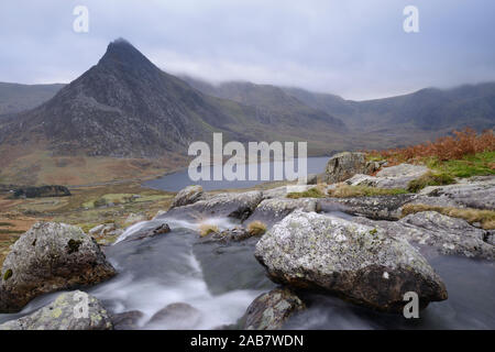 Water cascading down a fall on the Afon Lloer, overlooking the Ogwen Valley and Tryfan in the Glyderau mountain range, Snowdonia, Wales, UK Stock Photo