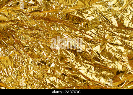 Gold leaf background texture with shiny crumpled uneven surface. Golden foil crumpled background texture Stock Photo