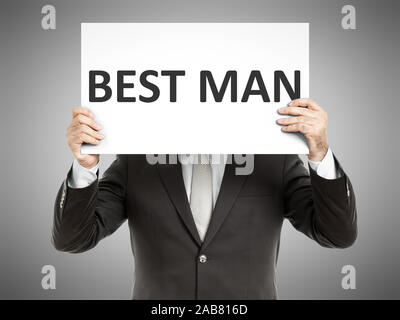 Ein Geschaeftsmann, der ein Schild mit den Worten 'Best Man' in der Hand haelt Stock Photo