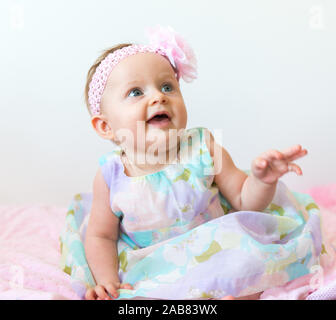 Cute 6 months old baby girl wearing beauty dress on light background Stock Photo