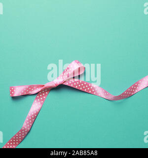 Decorative pink bow ribbon on mint background Stock Photo