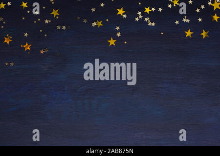 Dark-blue wooden background with golden stars with copy space for text. Stock Photo