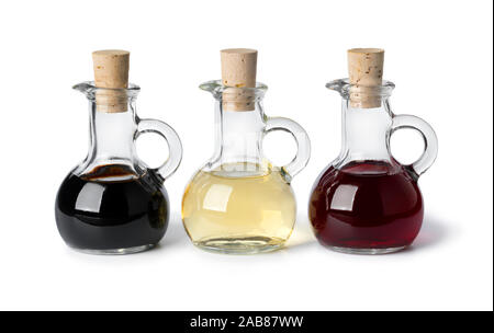 Three glass bottles with different types of vinegar isolated on white background Stock Photo