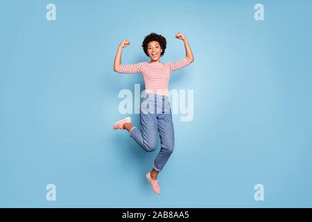 Full length body size photo of cheerful positive cute nice pretty sweet girlfriend wearing jeans denim striped shirt footwear jumping isolated pastel Stock Photo