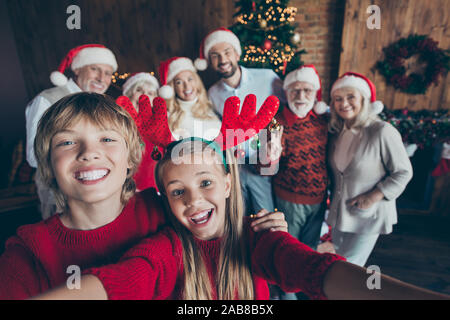 Self photo of large family meeting together with couple of brother sister taking selfie on background of their relatives parents grandparents and Stock Photo