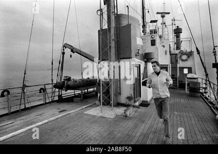 Pirate radio station Radio Laser 558 off shore the coast of Felixstowe Suffolk 1980s UK.  They are transmitting from international waters in the North Sea. DJ Ric Harris keeping fit on deck of the ship. 1984 England HOMER SYKES Stock Photo