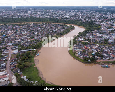 Aerial drone view of Acre river curves skyline in the amazon and Rio Branco city center buildings, streets on cloudy winter day. Brazil. Stock Photo