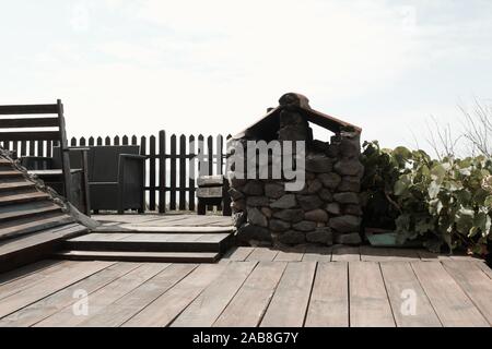 Wooden floor in the garden with an old stone oven and a wooden fence (Madeira, Portugal, Europe) Stock Photo
