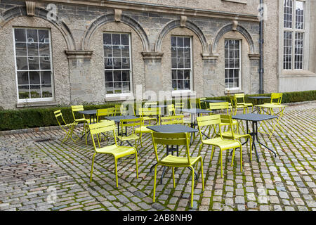 Empty chairs and tables on cobblestone courtyard in the IMMA, Kilmainham hospital, Irish Museum of Modern Art, Dublin, Ireland Stock Photo