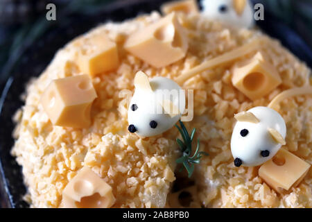 New Year 2020 salad. Mouse salad in cheese with pineapple and cheese. Decorations in the form of egg mice. Stock Photo