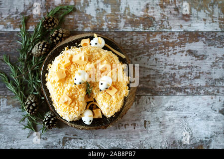 New Year 2020 salad. Mouse salad in cheese with pineapple and cheese. Decorations in the form of egg mice. Stock Photo