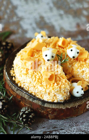 New Year 2020 salad. Mouse salad in cheese with pineapple and cheese. Decorations in the form of egg mice. Stock Photo