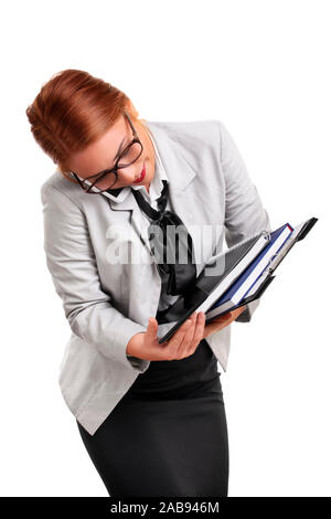 Portrait of a busy beautiful young businesswoman talking on the phone, trying to keep the notepads, clipboard and tablet from falling, isolated. Stock Photo