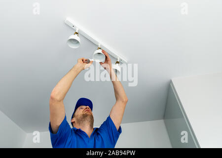 electrician installing led light bulbs in ceiling lamp Stock Photo