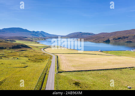 Drone shoot over A838 road with view stretching over Kyle of Durness and Beinn Spionnaidh at bright autumnal day in Northwest highlands of Scotland - Stock Photo