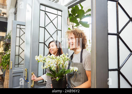 Happy florist team with flower as present for business opening Stock Photo
