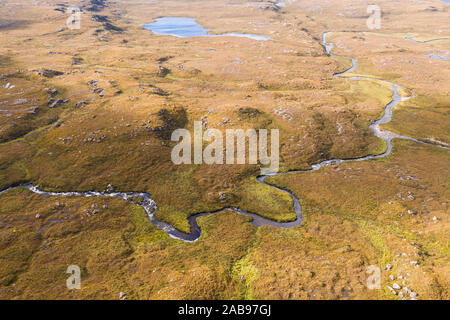 High altitude drone shoot over winding river across scenic moorland in the North West Highlands of Scotland - NC500 Route Stock Photo