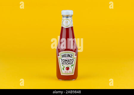 A bottle of Heinz Tomato Ketchup shot on a yellow background. Stock Photo