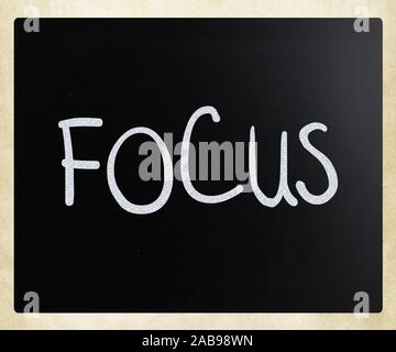 The word ''Focus'' handwritten with white chalk on a blackboard.