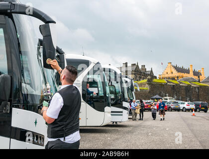 Coach and bus park with bus driver cleaning window, castle esplanade, Stirling Castle, Scotland, UK Stock Photo