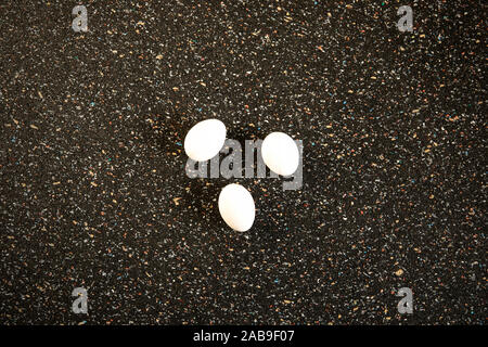 Still life, abstract arrangement white eggs flat lay on speckle  black background with copy space. Minimalistic food art. Pop art style. New life conc Stock Photo