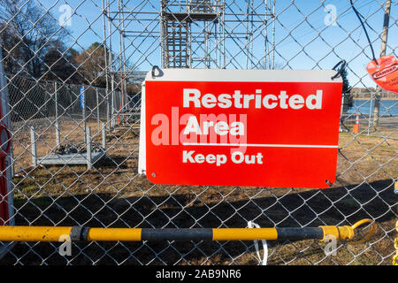 Restricted Area Keep Out red and white sign on chain link fence at construction site Stock Photo