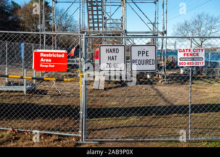 Restricted Area Keep Out, Hard Hat Area, PPE Required signs on chain link fence at construction site by Gate City Fence Temporary Fencing Stock Photo