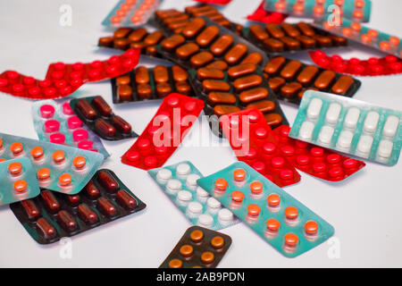 Different tablets, pills in foil blister packs, medications drugs on white background Stock Photo