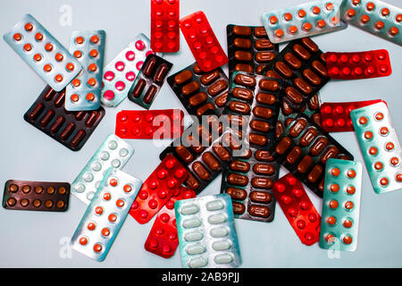 Different tablets, pills in foil blister packs, medications drugs on white background Stock Photo