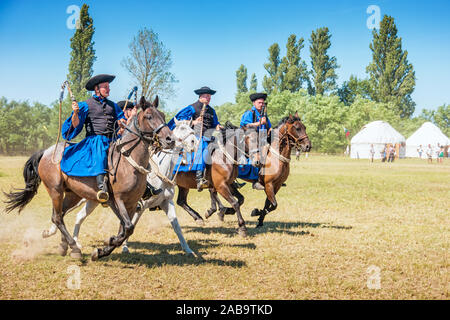 Traditional Hungarian shepherd horsemen ride during the Day of Ancestors tribal assembly in the Hungarian steppe near Bugac, Hungary. Stock Photo