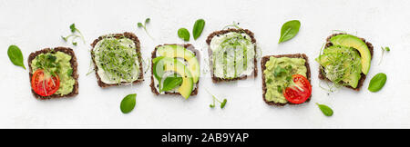 Vegetarian toasts with avocado, tofu, tomato and microgreen Stock Photo