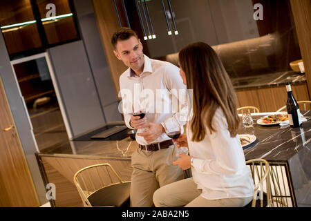 Sweet young couple drinking red wine after romantic dinner at luxury kitchen Stock Photo